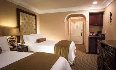 a hotel room with two beds and a door at Best Western Plus Sunset Plaza Hotel in Los Angeles
