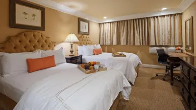 a hotel room with two beds and a desk at Best Western Plus Sunset Plaza Hotel in Los Angeles