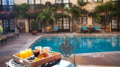 a tray of food on a table next to a pool at Best Western Plus Sunset Plaza Hotel in Los Angeles
