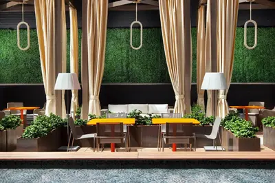 a restaurant with yellow tables and chairs and plants at Sheraton Grand Los Angeles in Los Angeles