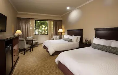 a hotel room with two beds and a television at Coast Burbank Hotel in Burbank