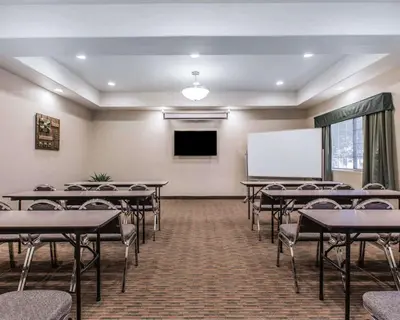 a conference room with tables and a white screen at Quality Inn Rosemead-Los Angeles in Rosemead