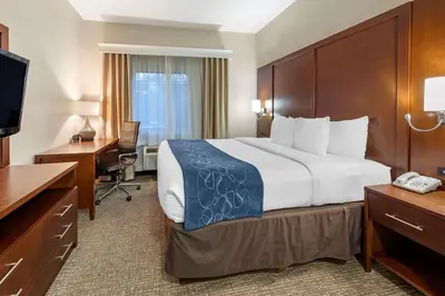 a hotel room with a large bed and a desk at Citrus Suites Redlands Loma Linda Hotel in Redlands
