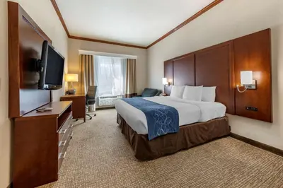 a hotel room with a bed and a flat screen tv at Citrus Suites Redlands Loma Linda Hotel in Redlands