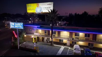a building with a large billboard on top of it at night at GAREY MOTEL in Pomona