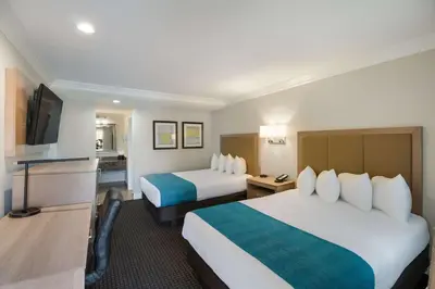 a hotel room with two beds and a flat screen tv at Best Western Woodland Hills in Woodland Hills
