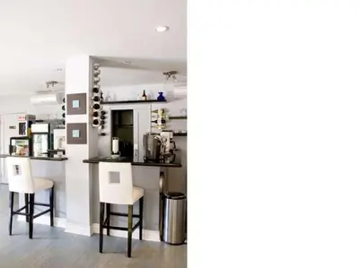 a kitchen with two white stools and a counter at L.A. Sky Boutique Hotel in Los Angeles