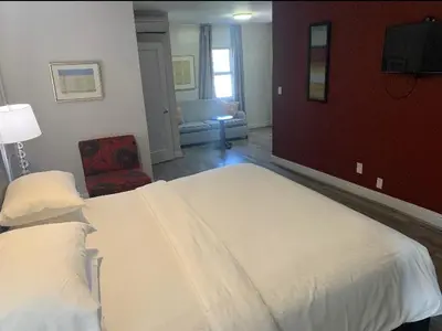 a bedroom with a large white bed and a chair at L.A. Sky Boutique Hotel in Los Angeles