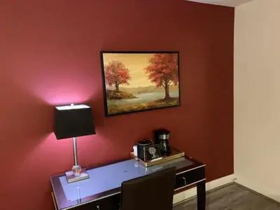 a desk with a lamp and a painting on a wall at L.A. Sky Boutique Hotel in Los Angeles