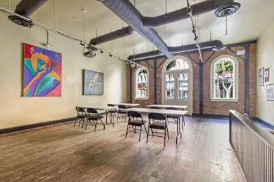 a room with tables and chairs and a painting on the wall at HI Los Angeles Santa Monica Hostel in Los Angeles