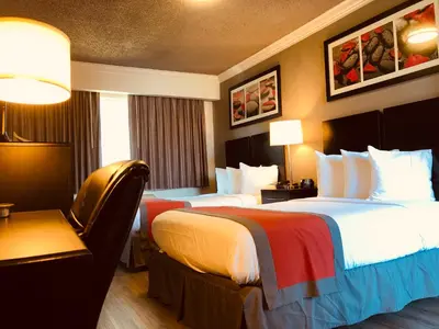 a hotel room with two beds and a chair at The Lexmar - Dodger Stadium Hollywood in Los Angeles