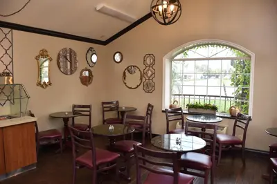 a restaurant with tables and chairs and a window at Dynasty Suites Redlands in Redlands