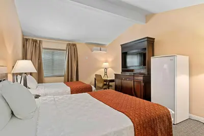 a hotel room with two beds and a flat screen tv at The Lemon Tree Hotel in Anaheim