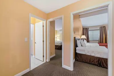 a bedroom with two beds and an open door at The Lemon Tree Hotel in Anaheim