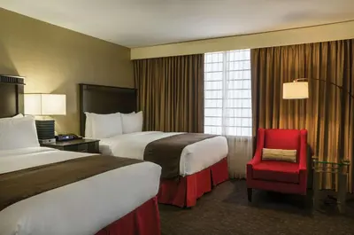 a hotel room with two beds and a red chair at Doubletree by Hilton Los Angeles Downtown in Los Angeles