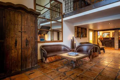 a living room with leather furniture and a table at Hotel Pepper Tree Boutique Kitchen Studios - Anaheim in Anaheim