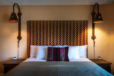a bedroom with a bed with two lamps and two pillows at Hotel Pepper Tree Boutique Kitchen Studios - Anaheim in Anaheim