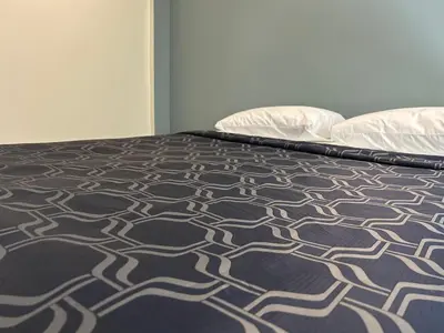 a bed with a black and white bedspread and two pillows at Budget Inn Hollywood in Los Angeles