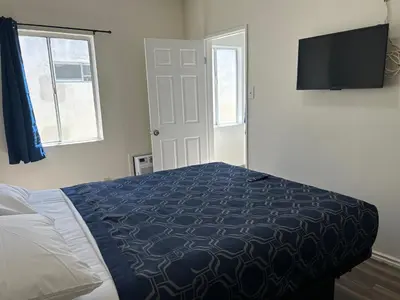 a bedroom with a bed and a flat screen tv at Budget Inn Hollywood in Los Angeles