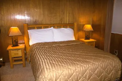 a bedroom with a bed and two lamps on tables at Goldmine Lodge in Big Bear Lake