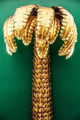a gold glove hanging on a green wall at The Prospect Hollywood in Los Angeles