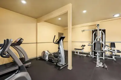 a gym with several tread machines in a room at Baymont by Wyndham Monterey Park in Monterey Park