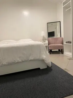a bedroom with a bed and a chair and a mirror at Culver City Hostel in Los Angeles