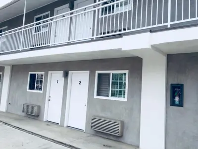 a building with two white doors and a balcony at Value Inn in Sylmar