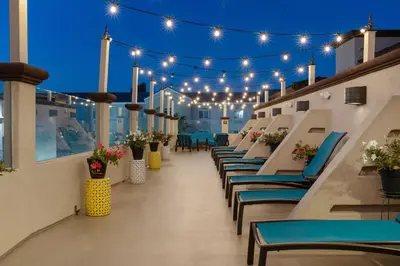 a rooftop patio with blue chairs and lights at Peacock Suites in Anaheim