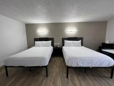 two beds in a room with white sheets at Motel 6-Orange, CA - Anaheim in Anaheim