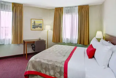 a hotel room with a large bed and a desk at Ramada by Wyndham Hawthorne/LAX in Hawthorne