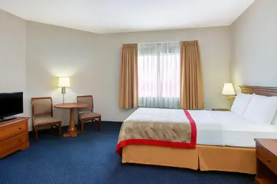 a hotel room with a bed and a television at Ramada by Wyndham Hawthorne/LAX in Hawthorne