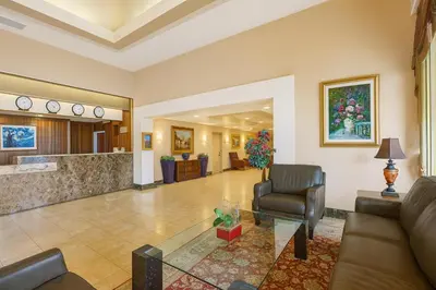 a lobby of a hotel with a couch and a chair at Ramada by Wyndham Hawthorne/LAX in Hawthorne