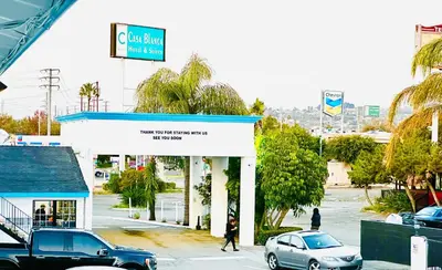 a car dealership with cars parked in a parking lot at Casa Blanca Hotel - Orange in Orange