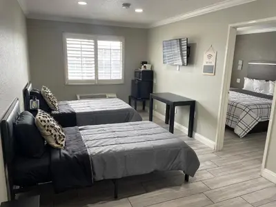 a hotel room with two beds and a mirror at Cabana Inn & Suites in Long Beach