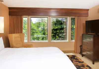 a bedroom with a bed and a large window at Lake Arrowhead Resort & Spa in Lake Arrowhead