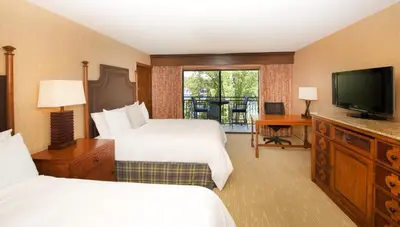 a hotel room with two beds and a flat screen tv at Lake Arrowhead Resort & Spa in Lake Arrowhead
