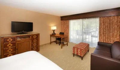 a hotel room with a bed and a flat screen tv at Lake Arrowhead Resort & Spa in Lake Arrowhead