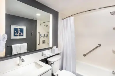 a bathroom with a toilet and a sink and a mirror at Four Points by Sheraton Los Angeles Westside in Los Angeles