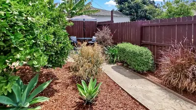 a backyard with a fence and a bench and plants at Studio Mins to LAX , Venice Beach & Sony Studios CC B in Los Angeles