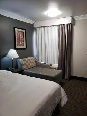 a hotel room with a bed and a couch at Portofino Inn Burbank in Burbank