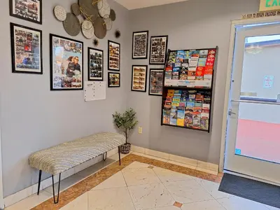 a room with a bench and pictures on the wall at Portofino Inn Burbank in Burbank