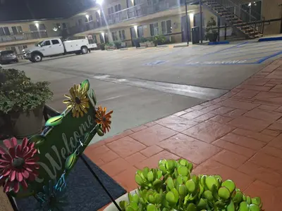 a sign in front of a parking lot at night at Portofino Inn Burbank in Burbank