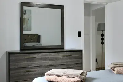 a bedroom with a dresser with a mirror on it at Chic Apartment in Los Angeles