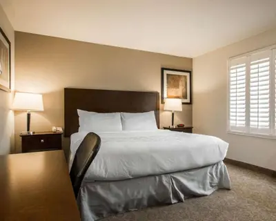 a bedroom with a large bed with two tables and two lamps at Rodeway Inn Convention Center in Los Angeles