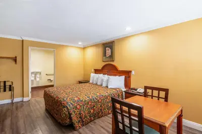 a hotel room with a bed and a table at Rodeway Inn Artesia Cerritos in Artesia
