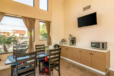 a kitchen with a table and chairs and a tv at Rodeway Inn Artesia Cerritos in Artesia