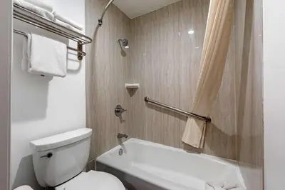 a white bathroom with a toilet and a shower at Rodeway Inn Carson - Los Angeles South in Carson