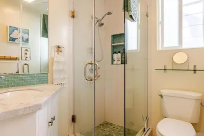 a bathroom with a shower and a toilet and a sink at Oceanfront Oasis in Long Beach