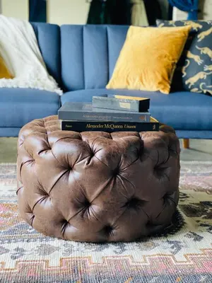 a brown ottoman with books on top of it in a living room at THE MIDNIGHT LOFT BY BOBOU DESIGN (KING SUITE) in Los Angeles